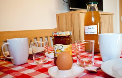 a table with an egg and glasses and a bottle at Gasserhof Aicha in Naz-Sciaves