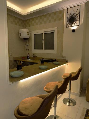 a bathroom with a counter with two sinks and two stools at One-77 in Cairo
