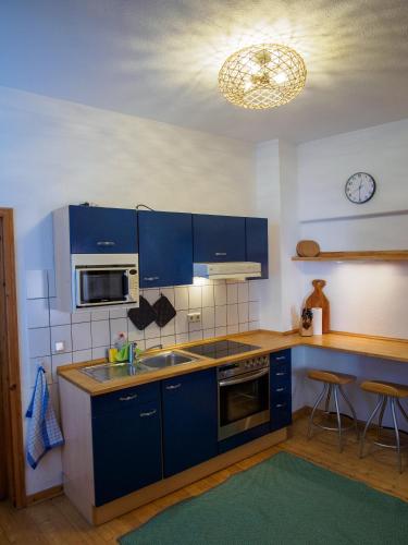 a kitchen with blue cabinets and a sink at Ferienwohnung in Ehrenbreitstein in Koblenz