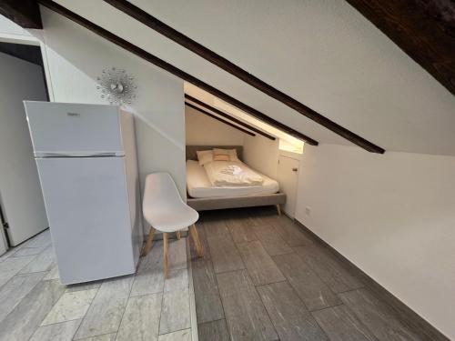 a small room with a bed and a white refrigerator at Hotel Surselva in Chur