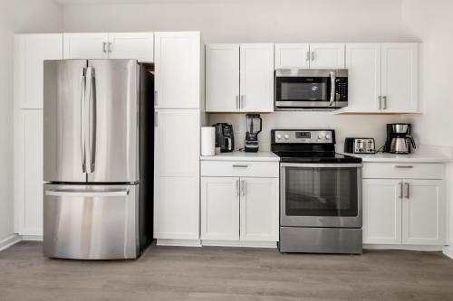 a kitchen with white cabinets and a stainless steel refrigerator at The Secret Nook in Charlotte