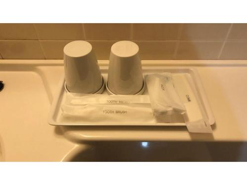 uma bandeja com duas chávenas em cima de um WC em Smile Hotel koriyama - Vacation STAY 48119v em Koriyama