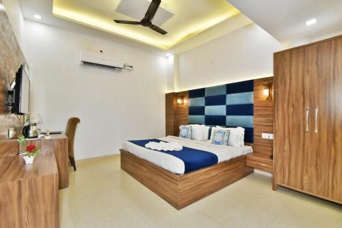 阿姆利则HK's Rooms & Dormitory的一间卧室，里面有一张床和一个吊扇