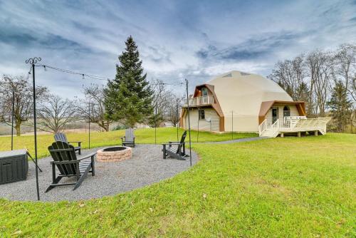 a yurt with chairs and a fire pit in a yard at The Dome' - Spacious Retreat Near Finger Lakes! in Penn Yan