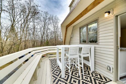 a porch with two white chairs and a table at The Dome' - Spacious Retreat Near Finger Lakes! in Penn Yan
