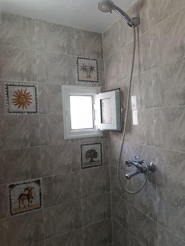 a bathroom with a shower with a window at Dar Hkaïem in Sousse