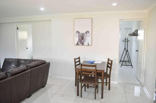 a living room with a couch and a table and chairs at ENTIRE WATERFRONT UNIT free WIFI in Dora Creek