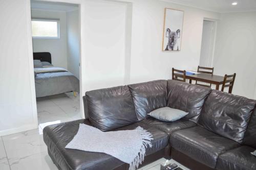 a brown leather couch in a living room at ENTIRE WATERFRONT UNIT free WIFI in Dora Creek