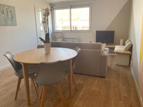 un salon avec une table et un canapé dans l'établissement L'APPART, proche mer et centre-ville, rénové en 2021, à Neufchâtel-Hardelot