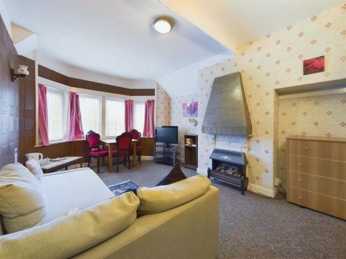 a living room with a couch and a television at Northcote Hotel in Bridlington