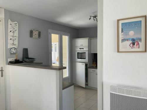 - une cuisine avec des appareils électroménagers blancs et un comptoir dans l'établissement Maison bercée par le bruit de la mer île de ré, à Sainte-Marie de Ré