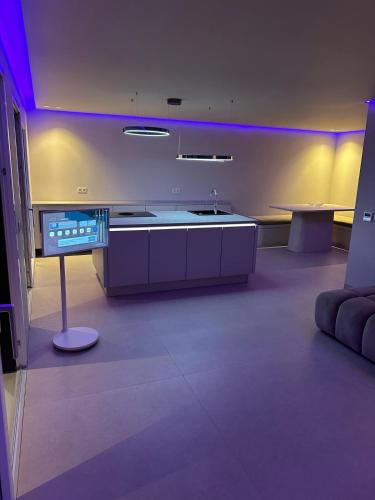a kitchen with a sink and a table with purple lights at Sal Apartment in Mindelo