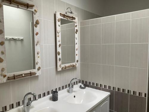 a bathroom with a sink and a mirror at Maison bercée par le bruit de la mer île de ré in Sainte-Marie-de-Ré