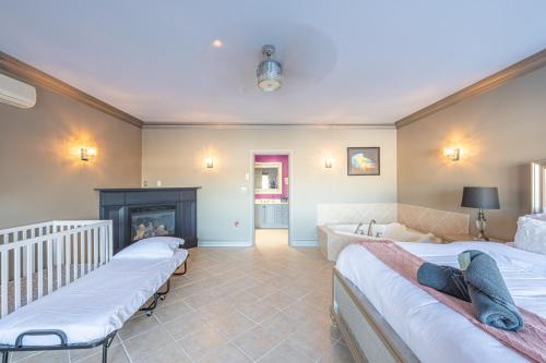 a bedroom with three beds and a fireplace at Lux Lakeside Escape Slps 20 with Pool, Golf Sim, Hot Tub, Karaoke, Gym and Sauna in Peterborough