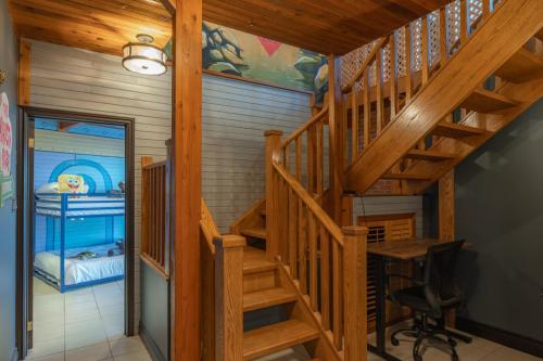 a wooden staircase in a home with a desk at Lux Lakeside Escape Slps 20 with Pool, Golf Sim, Hot Tub, Karaoke, Gym and Sauna in Peterborough