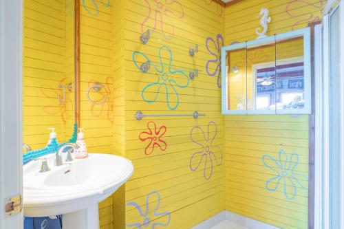 a bathroom with a sink and some drawings on the wall at Lux Lakeside Escape Slps 20 with Pool, Golf Sim, Hot Tub, Karaoke, Gym and Sauna in Peterborough