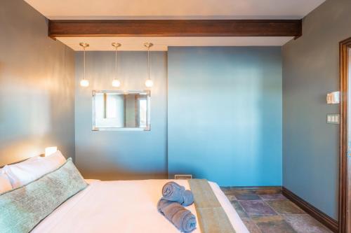 a bedroom with a bed with blue walls and a window at Lux Lakeside Escape Slps 20 with Pool, Golf Sim, Hot Tub, Karaoke, Gym and Sauna in Peterborough