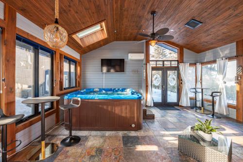 a room with a bed and a ceiling fan at Lux Lakeside Escape Slps 20 with Pool, Golf Sim, Hot Tub, Karaoke, Gym and Sauna in Peterborough