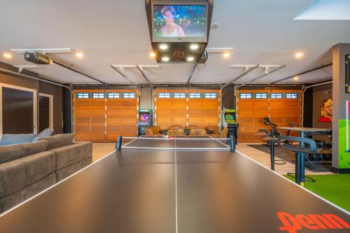 a living room with a ping pong table and a tv at Lux Lakeside Escape Slps 20 with Pool, Golf Sim, Hot Tub, Karaoke, Gym and Sauna in Peterborough
