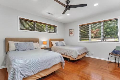 two beds in a room with two windows at Spacious property with Pool and walkable to downtown in Pinehurst