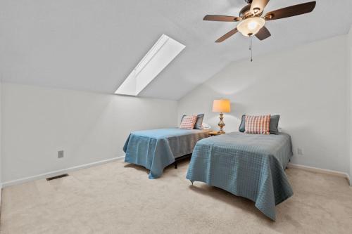 a bedroom with two beds and a ceiling fan at Pinehurst Manor 2BR Townhome in Pinehurst
