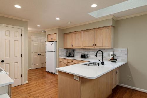 a kitchen with a sink and a white refrigerator at Pinehurst No. 6 Golf Front Getaway in Pinehurst