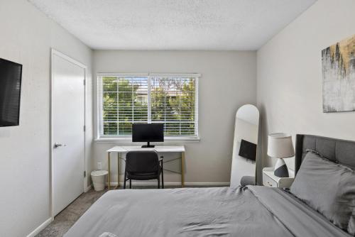 胡佛Stylish 2BR Duplex with Easy Access to Birmingham的一间卧室，配有一张床和一张带电脑的书桌