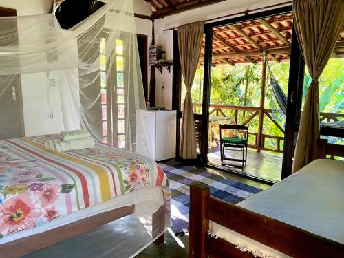パラチにあるEco Lodge in nature -10 min to Paraty centerlのベッドルーム1室(ベッド1台付)が備わります。ポーチの景色を望めます。