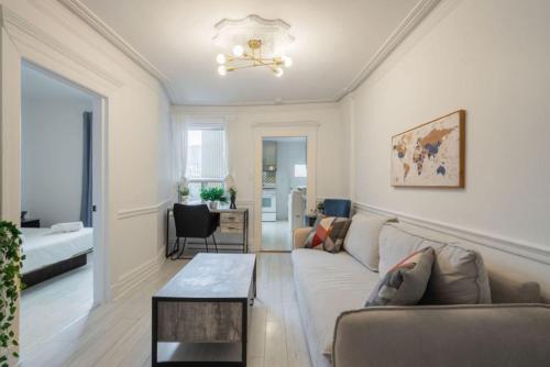 una sala de estar con un sofá y una mesa en Grand Urban 4BR Luxe Loft in Griffintown, en Montreal