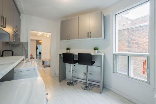 cocina con 2 taburetes en una habitación en Grand Urban 4BR Luxe Loft in Griffintown, en Montreal