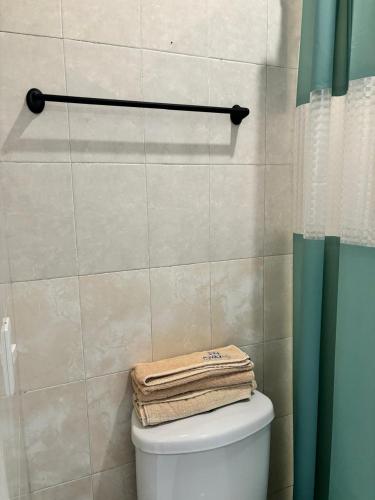 a bathroom with a toilet with towels on top of it at Hotel Awazul Bacalar in Bacalar