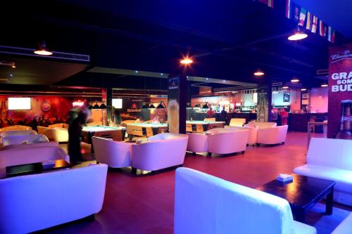 a restaurant with white tables and white chairs at Monroe Hotel & Suites in Manama