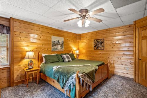 Un dormitorio con una cama y un ventilador de techo. en Starry Mountain View- Hot Tub - Pool Table - Prime Location, en Pigeon Forge