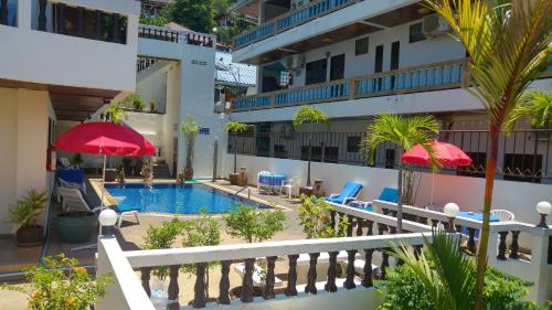 un hotel con piscina, sillas y sombrillas en Blue Sky Residence, en Patong Beach