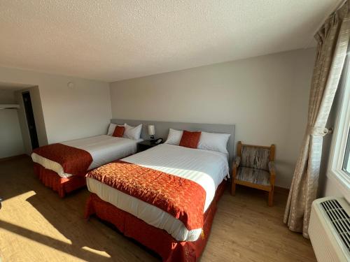 a bedroom with two beds and a window at The Lodge Inn in Edmonton