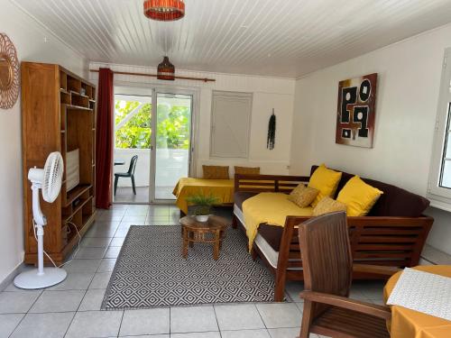 a living room with a couch and a bed at Les Lauriers du Rocher 1 in Le Diamant