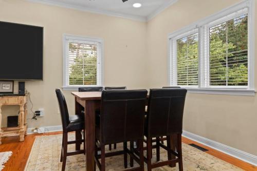 a dining room with a table and chairs and a tv at Downtown Village of Pinehurst 2BR 2BA in Pinehurst