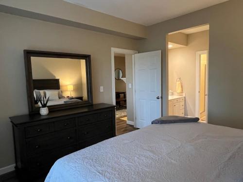 a bedroom with a bed with a dresser and a mirror at Golf Front Longleaf Condo2BR 2BA in Southern Pines