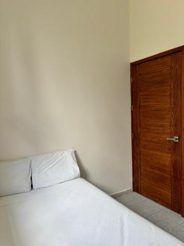 a bedroom with a bed with a wooden door at Hotel Awazul Bacalar in Bacalar