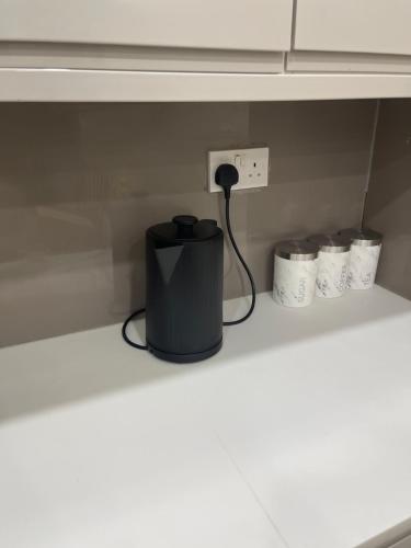 a black trash can on a shelf in a kitchen at Luxury 2 bed house and Pool table in Harborne in Birmingham
