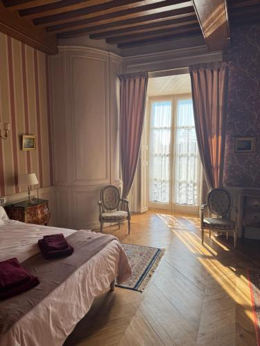 a bedroom with a bed and a large window at Guest-House Château de Longecourt en Plaine in Longecourt-en-Plaine