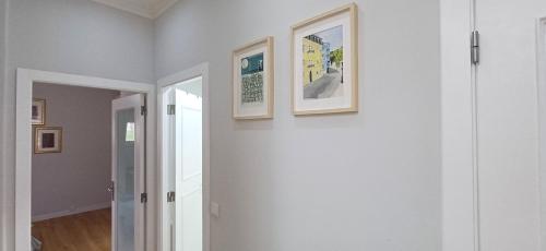a hallway with two framed pictures on a wall at Lxroller Seomara Apartment 3 Bdr in Amadora
