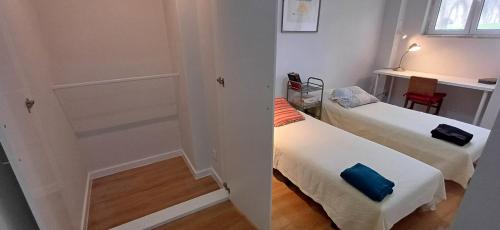 a small room with two beds and a window at Lxroller Seomara Apartment 3 Bdr in Amadora