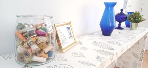 a table with a glass jar filled with lots of wooden beads at Lxroller Seomara Apartment 3 Bdr in Amadora