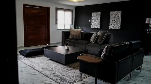 a living room with a couch and a coffee table at Spacious Black Themed Apartment Victoria Island in Lagos