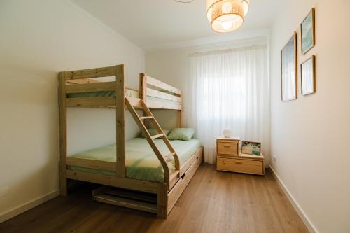 a bedroom with two bunk beds and a window at Casa do Sargaço Moledo in Moledo