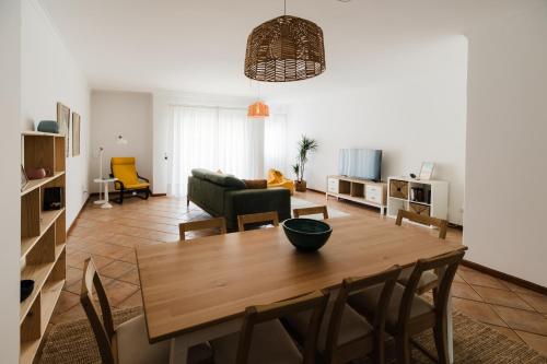 a living room with a wooden table and chairs at Casa do Sargaço Moledo in Moledo