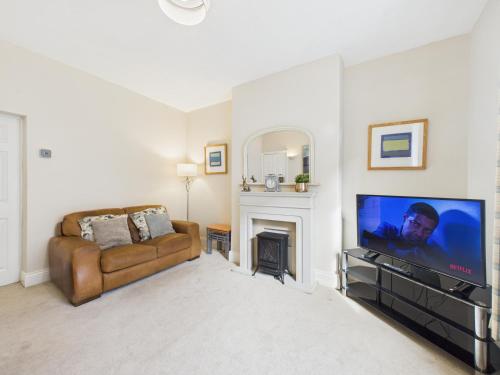 a living room with a couch and a flat screen tv at RestfullStays- 3 Bedroom, 4 Bed House FREE PARKING in Whitley Bay