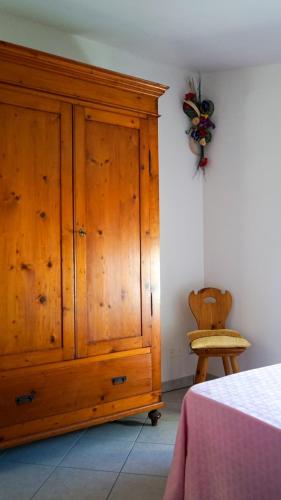 a wooden cabinet in a bedroom next to a chair at Casa Silvia I mit Garden in Albisano