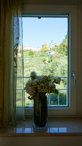 a vase of flowers sitting in front of a window at Casa Silvia I mit Garden in Albisano